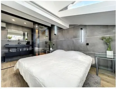 a bedroom with a large white bed and a sink at Appartement Palais des Festivals in Cannes