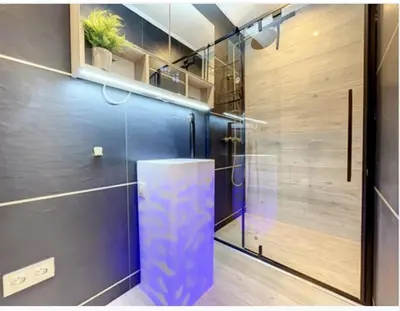 a bathroom with a shower and a blue wall at Appartement Palais des Festivals in Cannes
