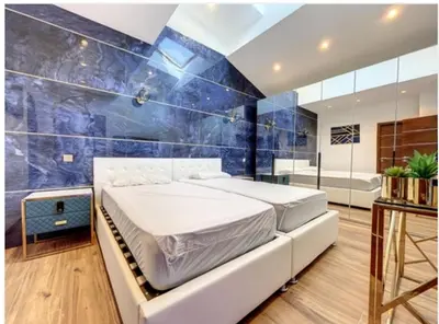 a bedroom with a bed and a blue wall at Appartement Palais des Festivals in Cannes