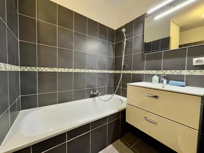 a bathroom with a white bath tub and a sink at Cannes Maria By SCLS Locations in Cannes