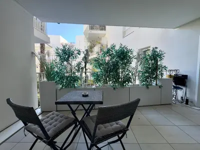 a table and chairs on a balcony with plants at Cannes Maria By SCLS Locations in Cannes