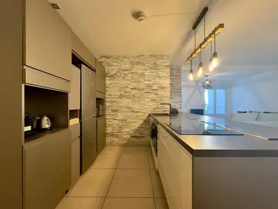 a kitchen with a counter and a stone wall at Cannes Maria By SCLS Locations in Cannes