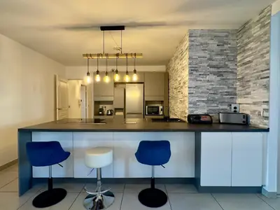 a kitchen with two blue chairs and a counter at Cannes Maria By SCLS Locations in Cannes
