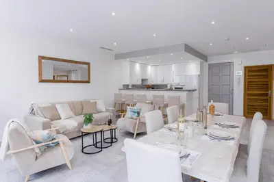 a dining room and living room with a table and chairs at 38 Meynadier 4p by Halldis in Cannes
