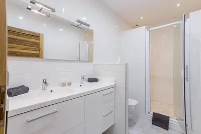 a white bathroom with a sink and a shower at 38 Meynadier 4p by Halldis in Cannes