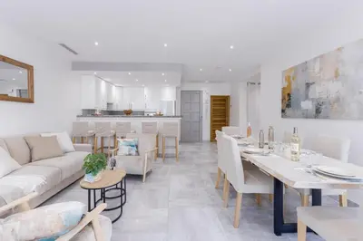 a white living room with a table and a couch at 38 Meynadier 4p by Halldis in Cannes