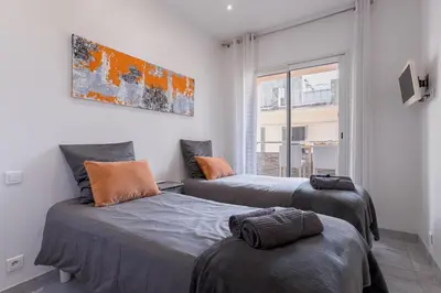 two beds in a room with a window at 38 Meynadier 4p by Halldis in Cannes