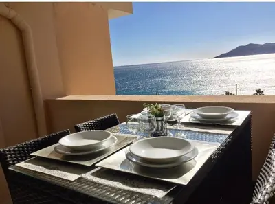 a table with plates and glasses and a view of the ocean at Appartement 531 in Cannes
