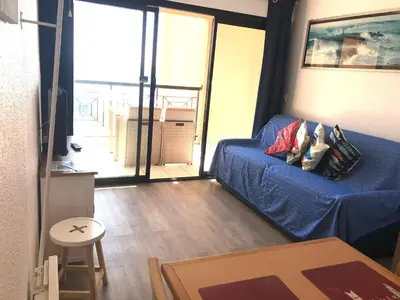 a living room with a blue couch and a balcony at Appartement 531 in Cannes