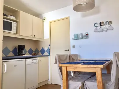 a kitchen and dining room with a table and a microwave at Appartement 531 in Cannes