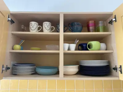a cabinet filled with plates and cups and dishes at Toit terrasse proche plages Croisette et Palais des Festivals in Cannes