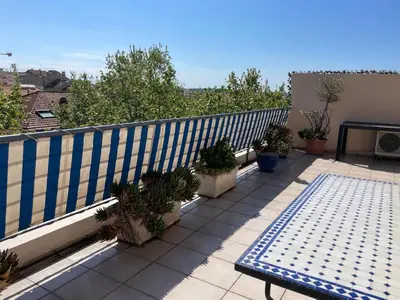 a balcony with potted plants and a blue and white fence at Toit terrasse proche plages Croisette et Palais des Festivals in Cannes