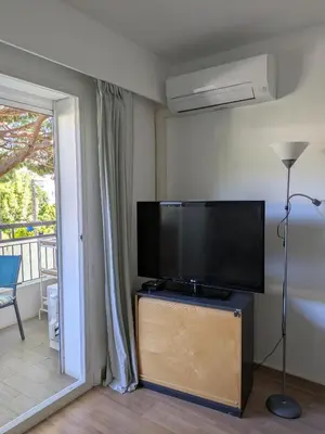 a living room with a flat screen tv on a stand at Cannes Isola Bella entre mer et montagne in Cannes