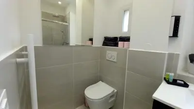 a white bathroom with a toilet and a sink at Lovely apartment heart of Cannes in Cannes