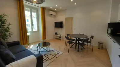 a living room with a couch and a table and chairs at Lovely apartment heart of Cannes in Cannes