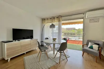 a living room with a table and a tv at Bright studio just outside Cannes in Le Cannet