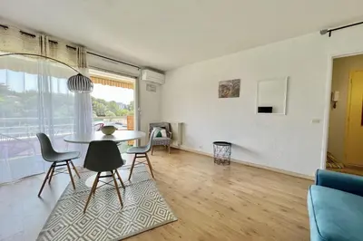 a living room with a table and chairs at Bright studio just outside Cannes in Le Cannet