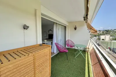 a room with a balcony with a table and chairs at Bright studio just outside Cannes in Le Cannet