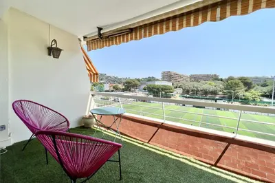 a balcony with two chairs and a tennis court at Bright studio just outside Cannes in Le Cannet