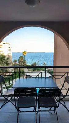 a table and chairs on a balcony with a view of the ocean at Résidence Pierre et Vacance 631 in Cannes