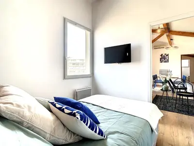 a bedroom with a bed and a tv on the wall at Appartement 3 chambres à proximité des plages in Cannes