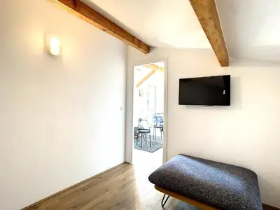 a living room with a couch and a tv on the wall at Appartement 3 chambres à proximité des plages in Cannes