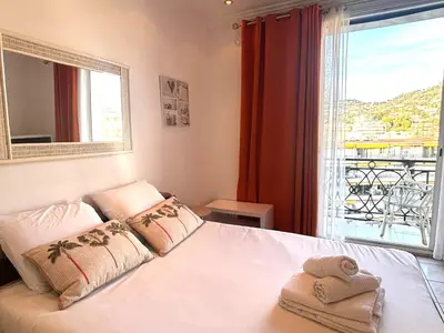 a bedroom with a bed and a television in it at Palais Miramar - Suite White Jardin - 20m Plage in Cannes