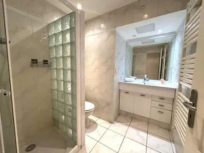 a mirror next to a picture on a wall at Palais Miramar - Suite White Jardin - 20m Plage in Cannes