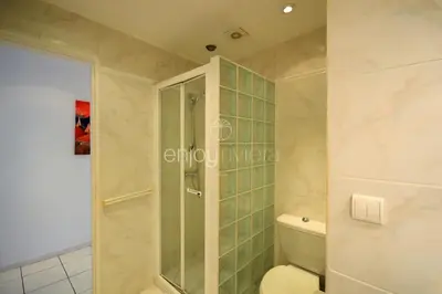 a kitchen with a counter and two stools at Palais Miramar - Suite White Jardin - 20m Plage in Cannes