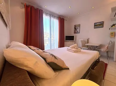 a bedroom with a white bed with two white towels at Palais Miramar - Suite White Jardin - 20m Plage in Cannes