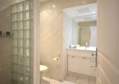 a bathroom with a toilet and a sink and a shower at Palais Miramar - Suite White Jardin - 20m Plage in Cannes