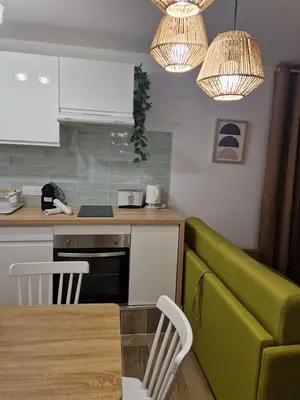 a kitchen with a table and a green couch at Studio cosy près de la Croisette in Cannes