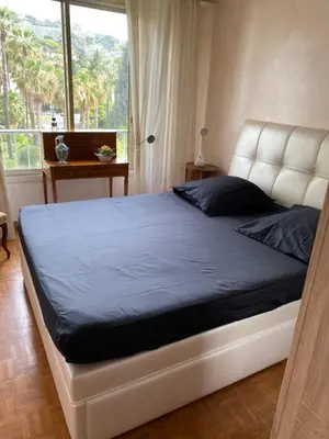 a bedroom with a large bed with a large window at Les Pervenches in Cannes