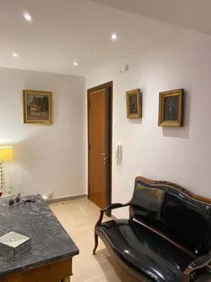a room with a chair and a table and a phone at Les Pervenches in Cannes