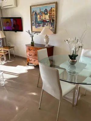 a dining room with a glass table and white chairs at Les Pervenches in Cannes