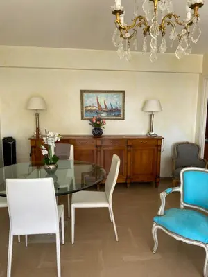 a dining room with a glass table and chairs at Les Pervenches in Cannes