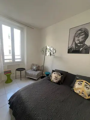 a bedroom with a bed with a black comforter at Studio au cœur de Cannes in Cannes