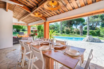 a dining room with a table and chairs and a pool at Dream Villa 300m2 & stunning 4000m2 private garden in Cannes