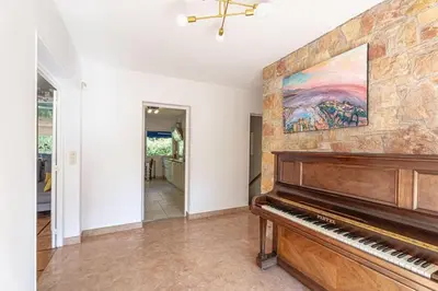 a piano in a living room with a painting on the wall at Dream Villa 300m2 & stunning 4000m2 private garden in Cannes