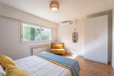 a bedroom with a bed and a chair and a window at Dream Villa 300m2 & stunning 4000m2 private garden in Cannes