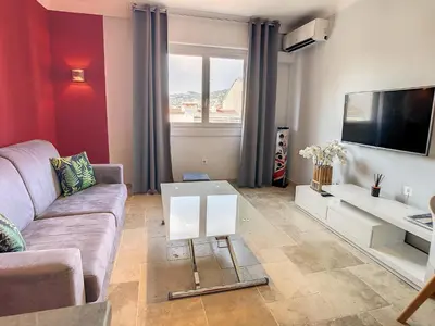 a living room with a couch and a tv at 1 bedroom rue d'Antibes , 1 min from the Croisette, 5 mins from the Palais 202 in Cannes