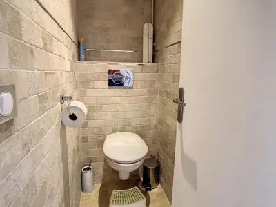a small bathroom with a toilet in a brick wall at 1 bedroom rue d'Antibes , 1 min from the Croisette, 5 mins from the Palais 202 in Cannes