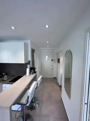 a kitchen with a counter and some chairs in it at Superbe 2 pièces, tout équipé centre de Cannes. in Cannes