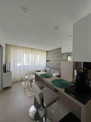 a living room with a kitchen and a table with chairs at Superbe 2 pièces, tout équipé centre de Cannes. in Cannes