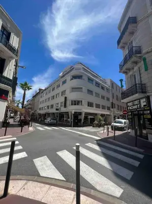 a city street with a large white building on the corner at Superbe 2 pièces, tout équipé centre de Cannes. in Cannes