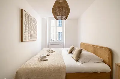 a bedroom with a bed with white sheets and a window at Beautiful 1BR, heart of Suquet-Cannes - 5min beach in Cannes