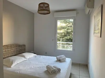 a white bedroom with a bed with towels on it at Alice in Cannes
