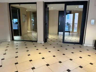 a hallway with two glass doors and a tiled floor at Alice in Cannes