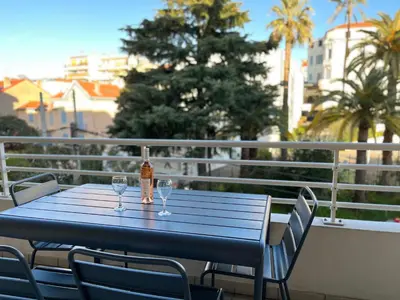 a blue table with two wine glasses on a balcony at Alice in Cannes