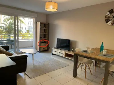 a living room with a table and a television at Alice in Cannes